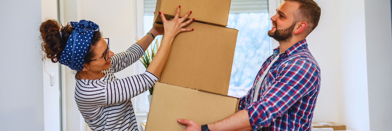 Couple buying first home and stacking boxed during the move.