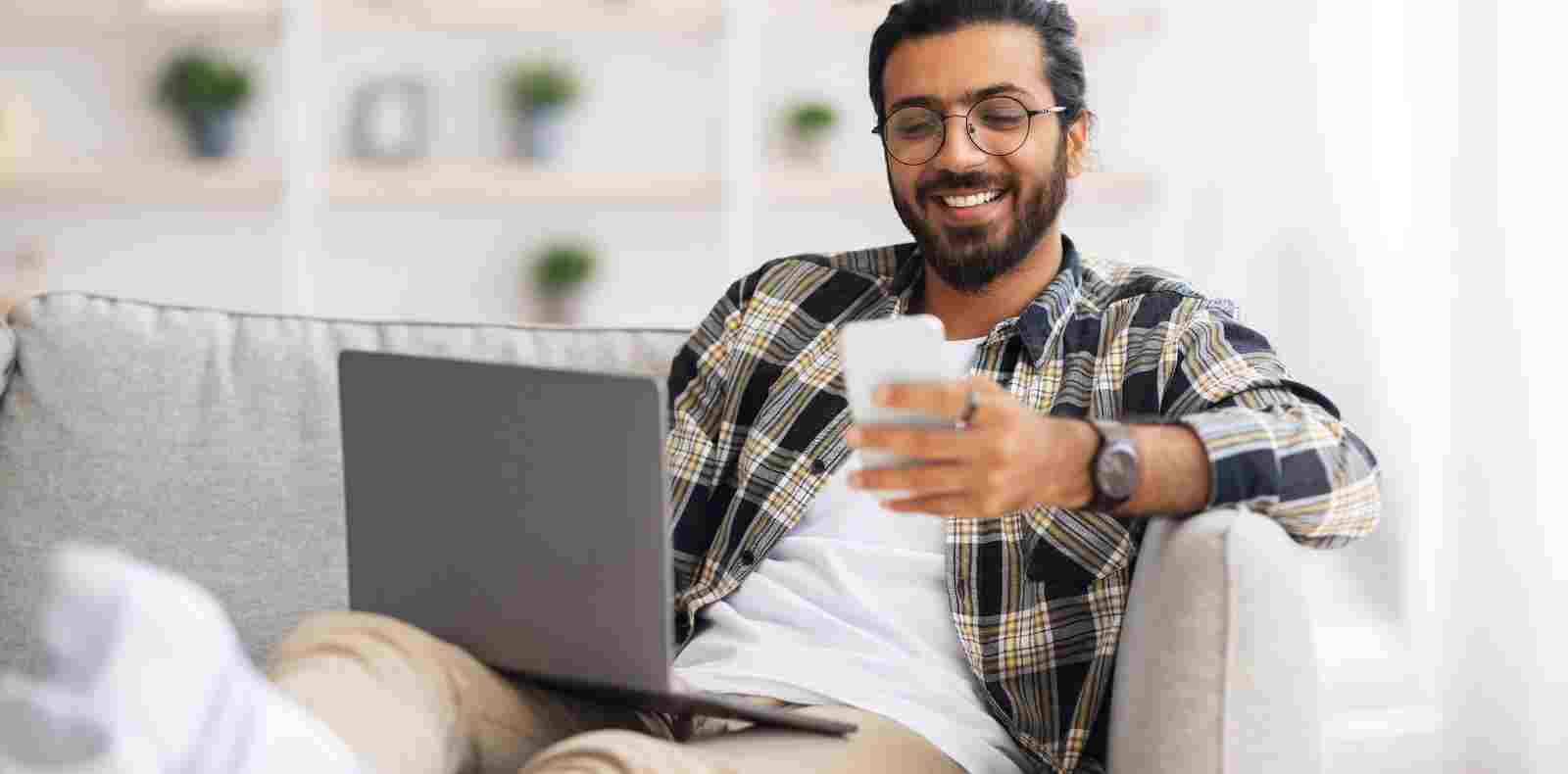 Guy with computer and phone sitting in living room