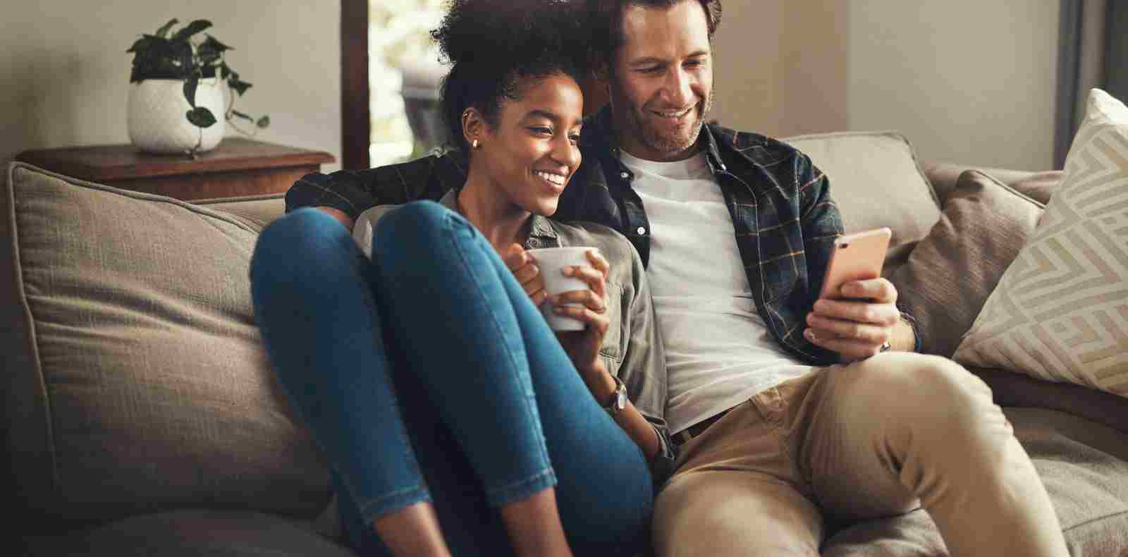 couple on the couch looking at smartphone