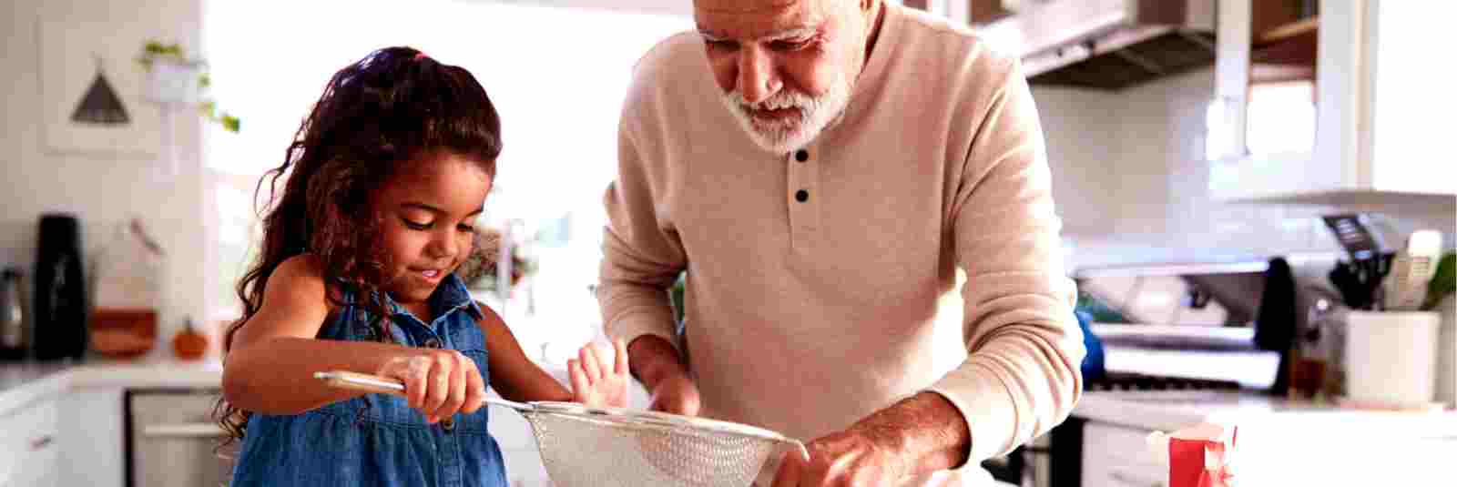 Grandpa cooking with granddaughter