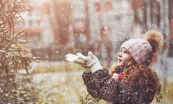 a little girl looking up at snowflakes